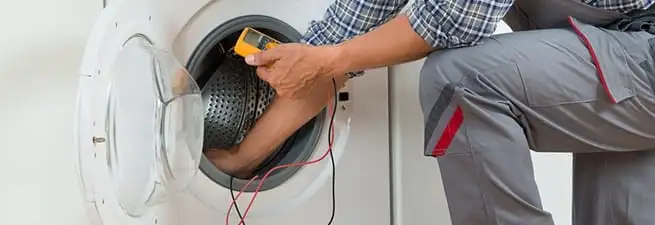Dryer repair technician inspecting and repairing a clothes dryer in Orlando, FL