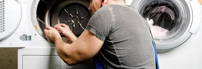 Dryer repair technician fixing a clothes dryer drum in Orlando, FL