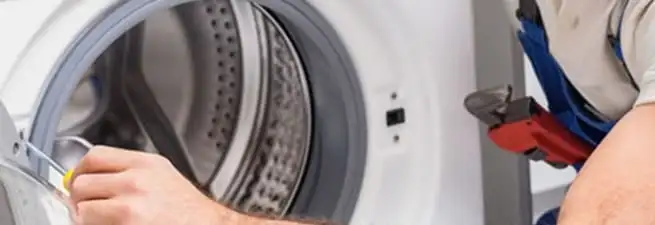 Appliance technician repairing a clothes dryer drum and internal parts in Orlando, FL