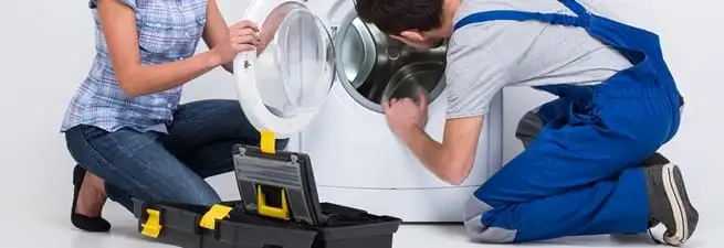 Washer repair technician inspecting a front-load washing machine with tools in Orlando, FL