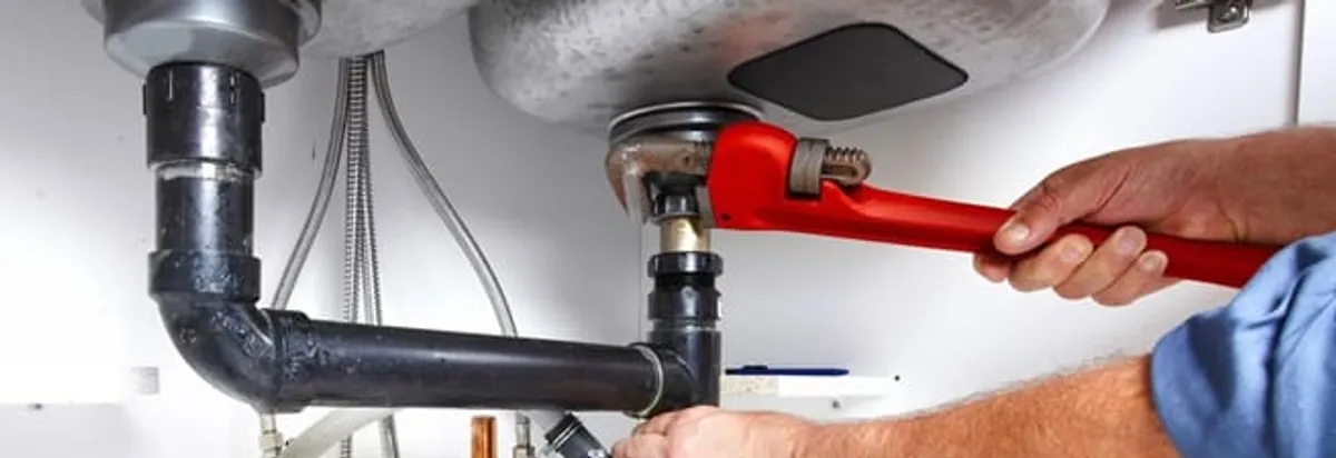 Garbage disposal repair technician tightening the sink drain and disposal connection in Orlando, FL