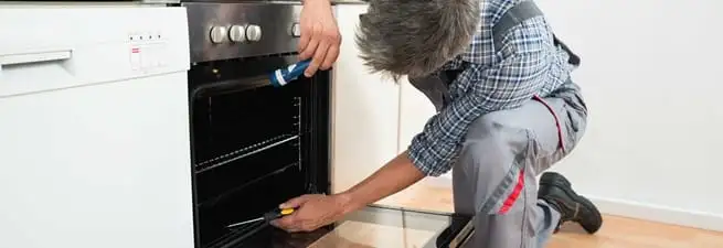 Oven repair technician inspecting and servicing an electric oven in Orlando, FL