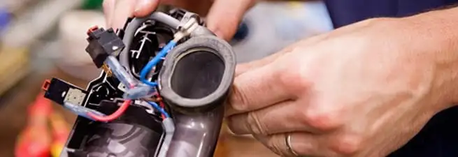 Vacuum repair technician reconnecting wiring and components in Orlando, FL