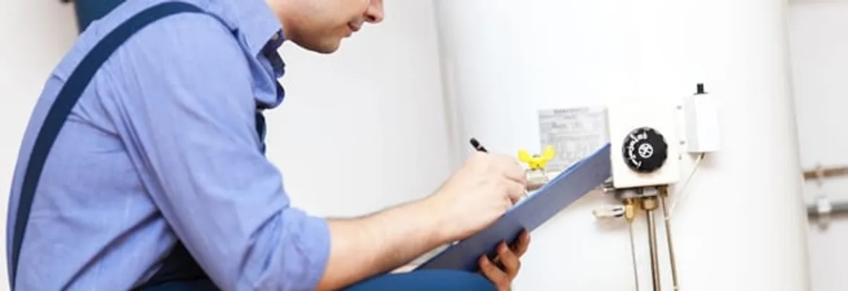 Water heater repair technician inspecting the unit and recording service notes in Orlando, FL
