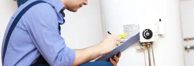 Water heater repair technician inspecting the unit and recording service notes in Orlando, FL