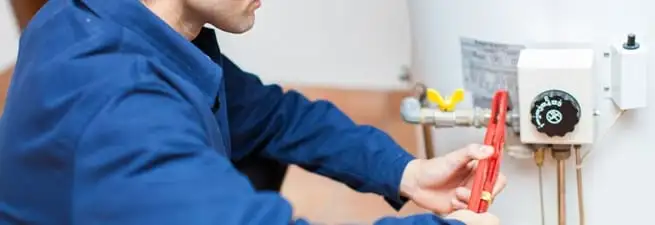 Water heater repair technician adjusting the temperature control and gas valve in Orlando, FL